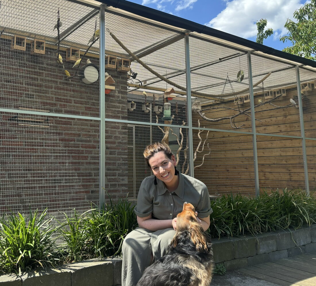 Shirley Kersten, lid van de raad van toezicht, met haar hond voor de volière