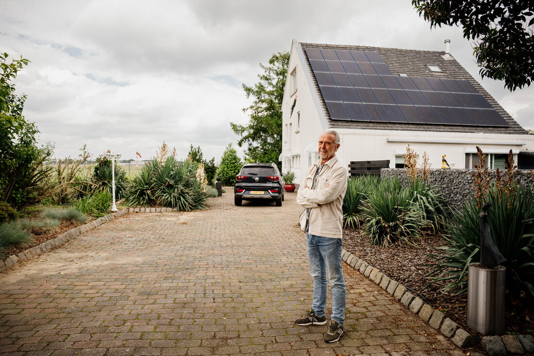 Omwonende John Huizinga voor zijn woning, op de achtergrond de luchthaven
