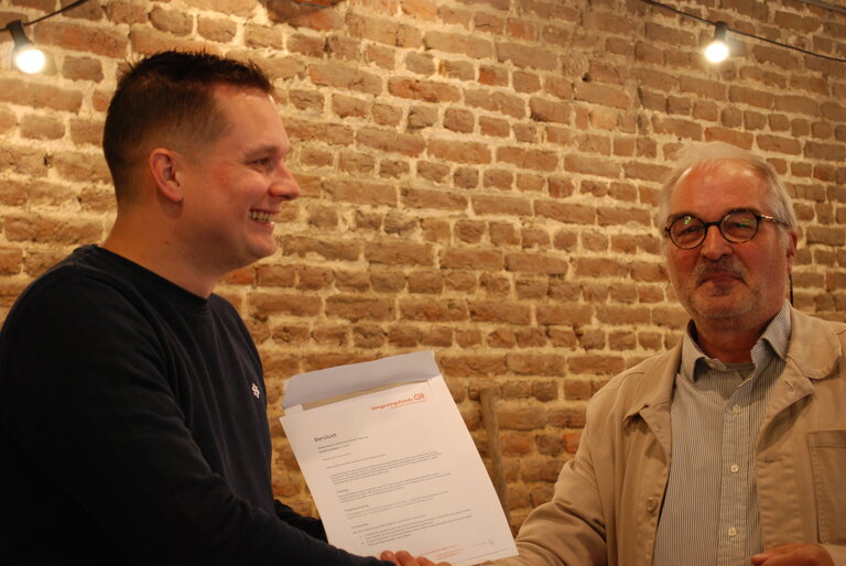 Voorzitter Tom Caelen van Buurtvereniging Geverik neemt het besluit van het fonds in ontvangst van Lou Wanten